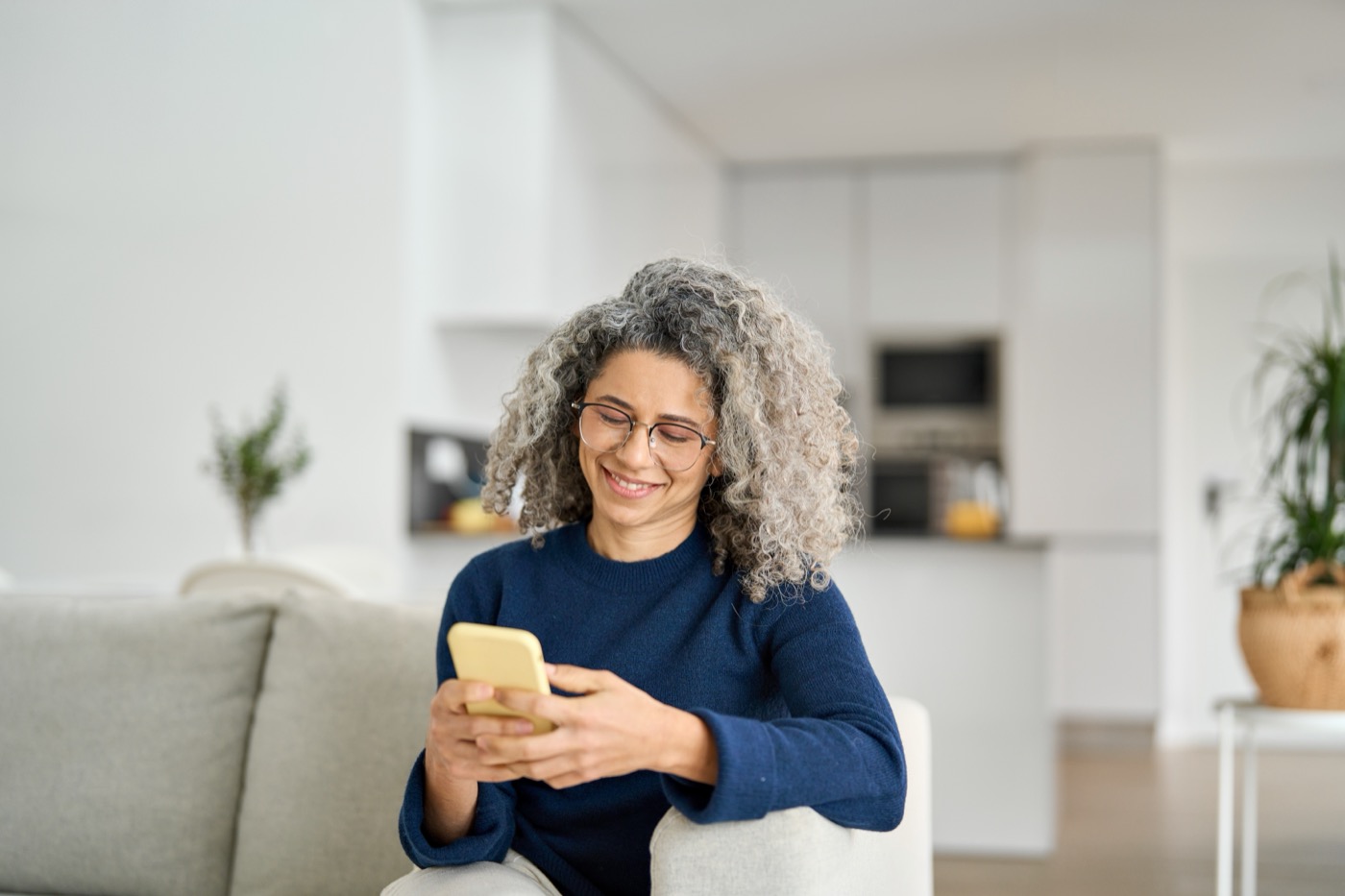 A woman at home reviewing her health record on her phone