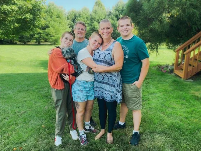 Renee Finch, second from right, is surrounded by her husband, Ernie Finch, and three of their children and puppy Wylla. Their children, from left to right, Emily Finch, Hannah Finch, and Paul Finch, shaved their heads with Renee Finch to show solidarity in her journey with multiple myeloma cancer.